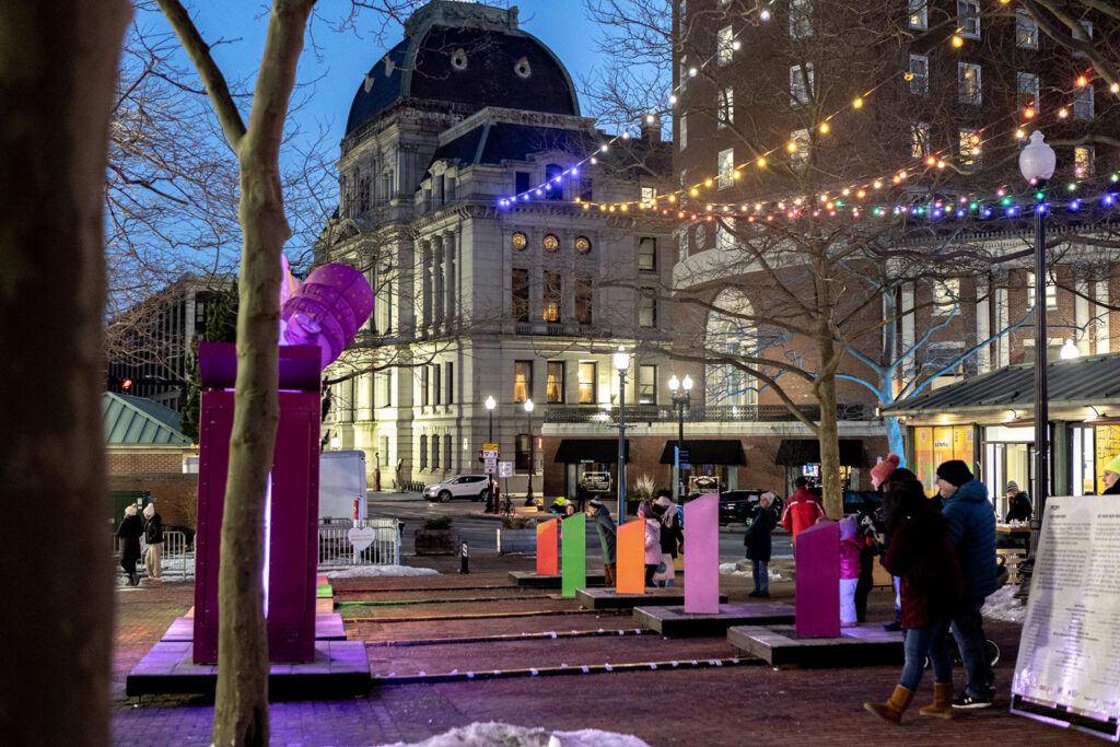 POP! from Gentilhomme at LUMINA festival, featuring colorful illuminated sculptures and a historic building in the background.